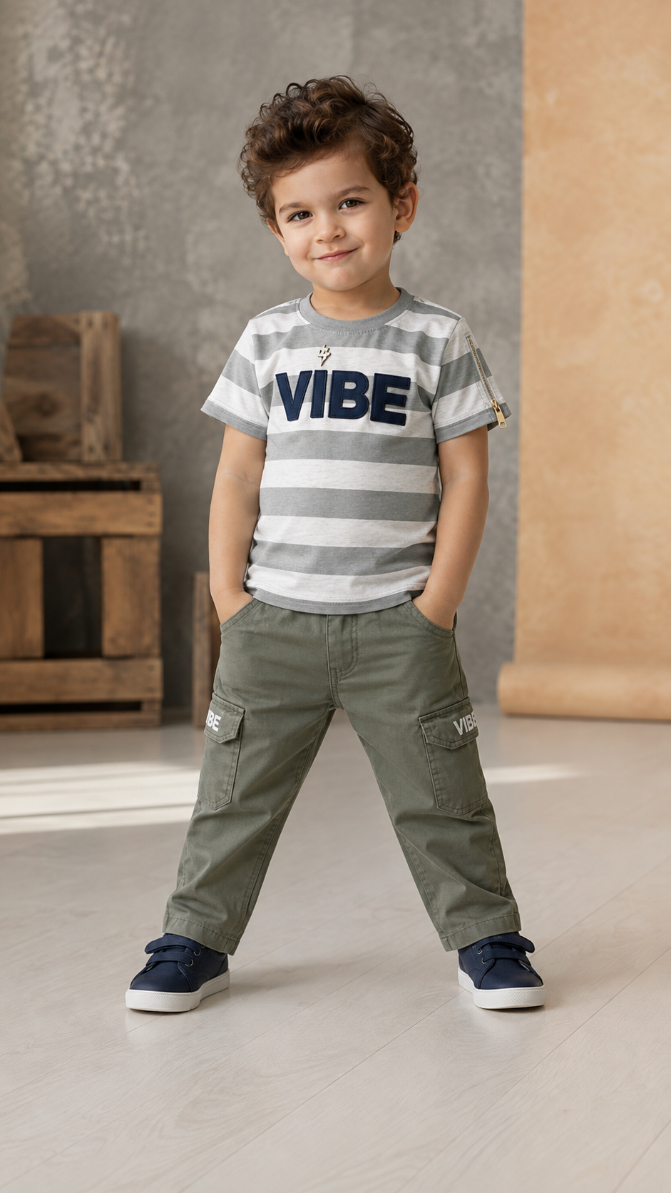 Boy wearing grey and white Vibe stripe tee with olive cargo pants standing confidently