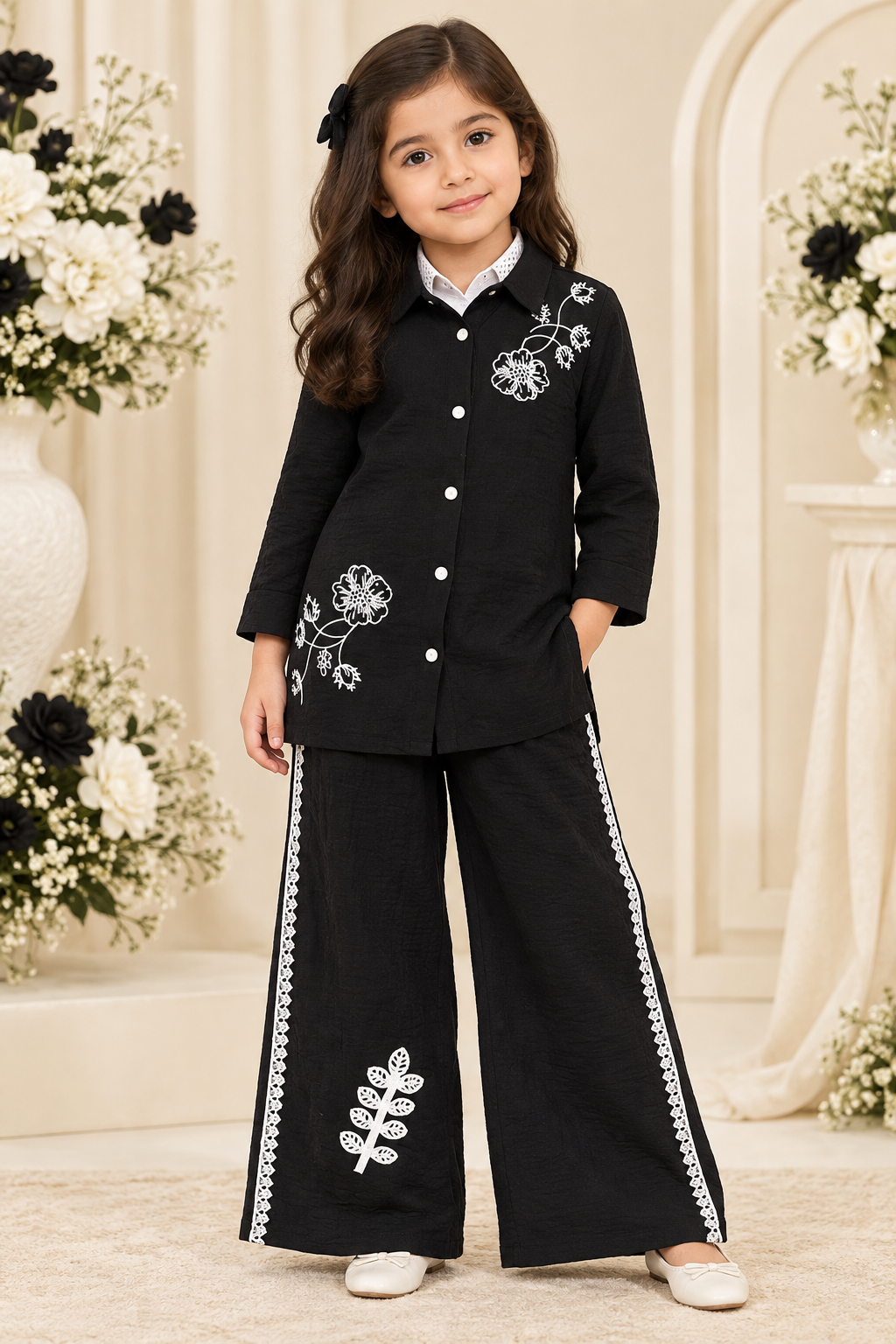 Girl wearing black floral embroidered tunic and black wide-leg pants with white trim