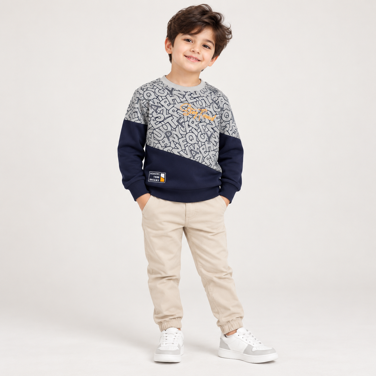 Boy wearing a grey and navy long-sleeve alphabet-patterned T-shirt