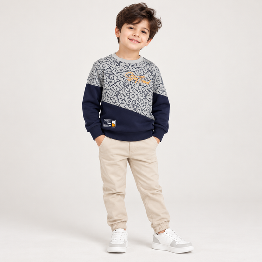 Boy wearing a grey and navy long-sleeve alphabet-patterned T-shirt