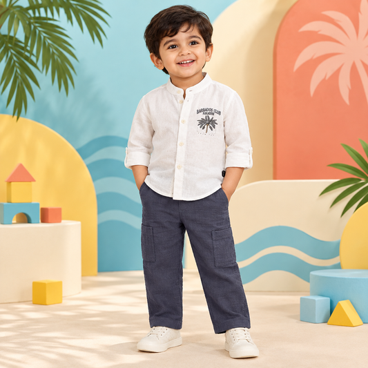 Toddler boy wearing Barbados Club shirt and grey pants with a clean covered waistband in a tropical studio