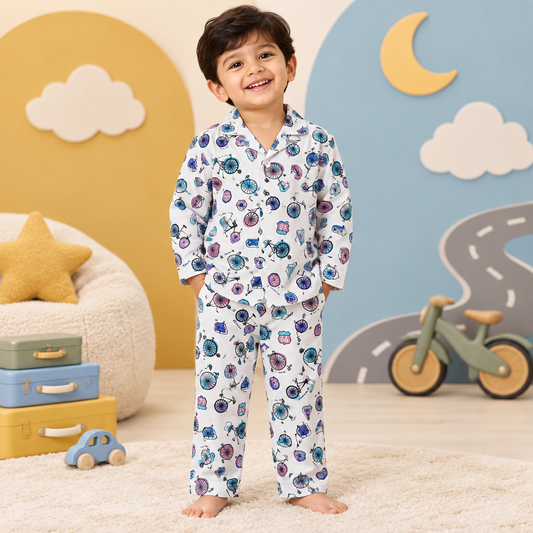 Toddler boy wearing Bicycle Road Trip print night suit in a cozy bedtime playroom