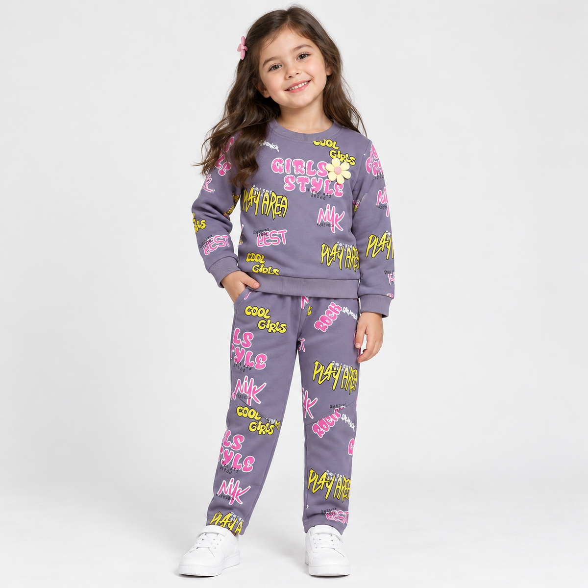 Girl wearing a purple sweatshirt and matching pants with pink and yellow graffiti-style prints