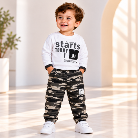 Boy wearing a white graphic long-sleeve top and camouflage-print joggers