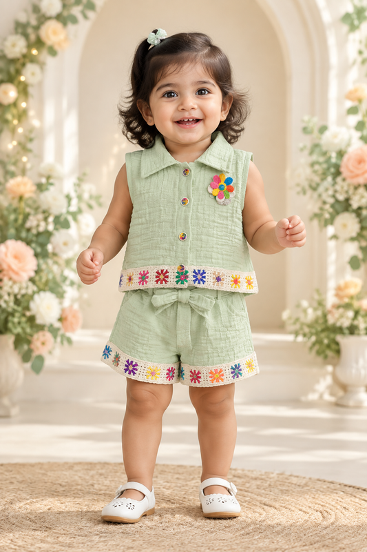 Toddler girl wearing mint green textured shirt and belted shorts