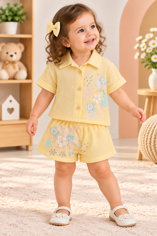 Girl wearing a pale yellow floral-detail collared shirt and matching shorts