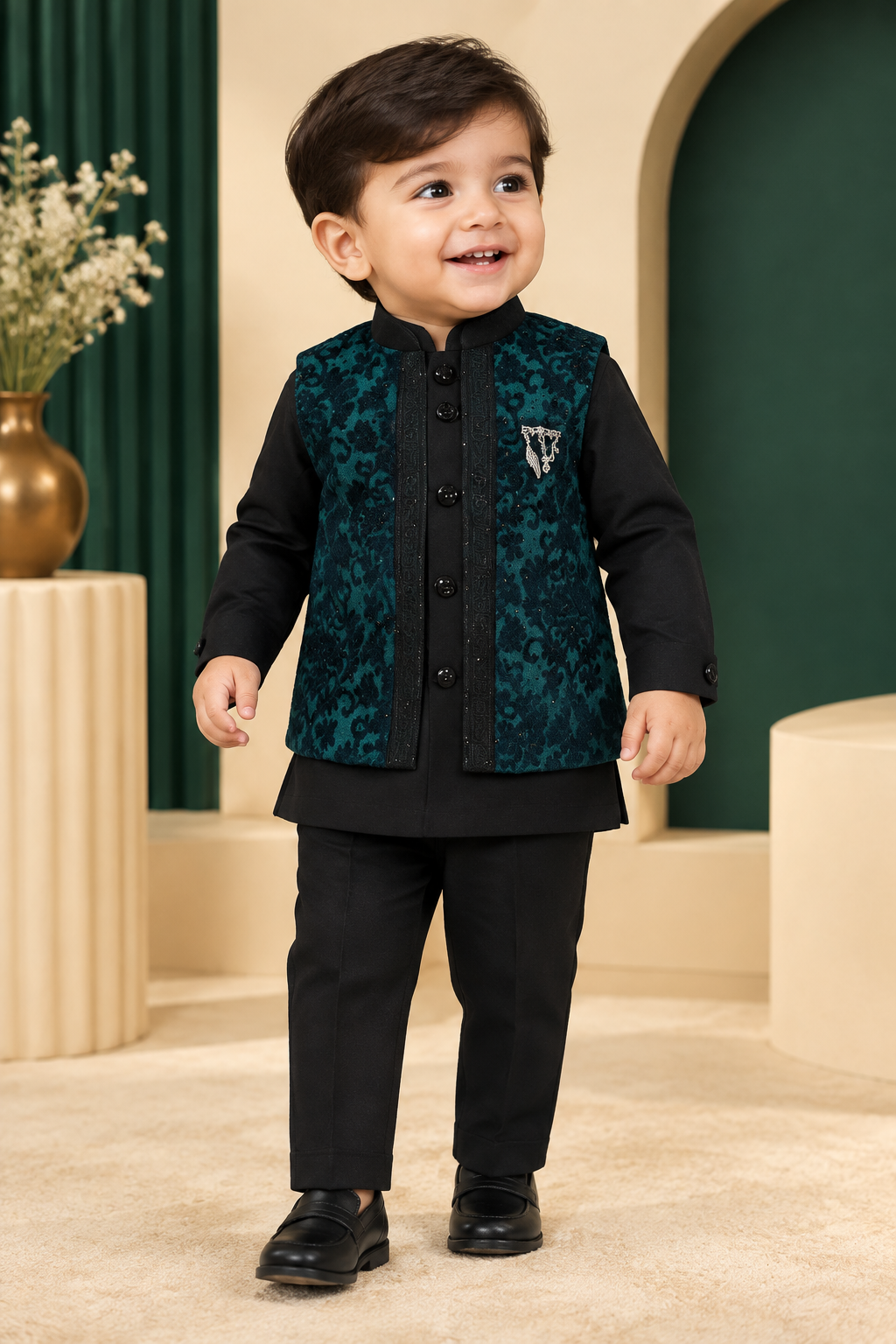 Toddler wearing dark green patterned waistcoat over black top and black pants
